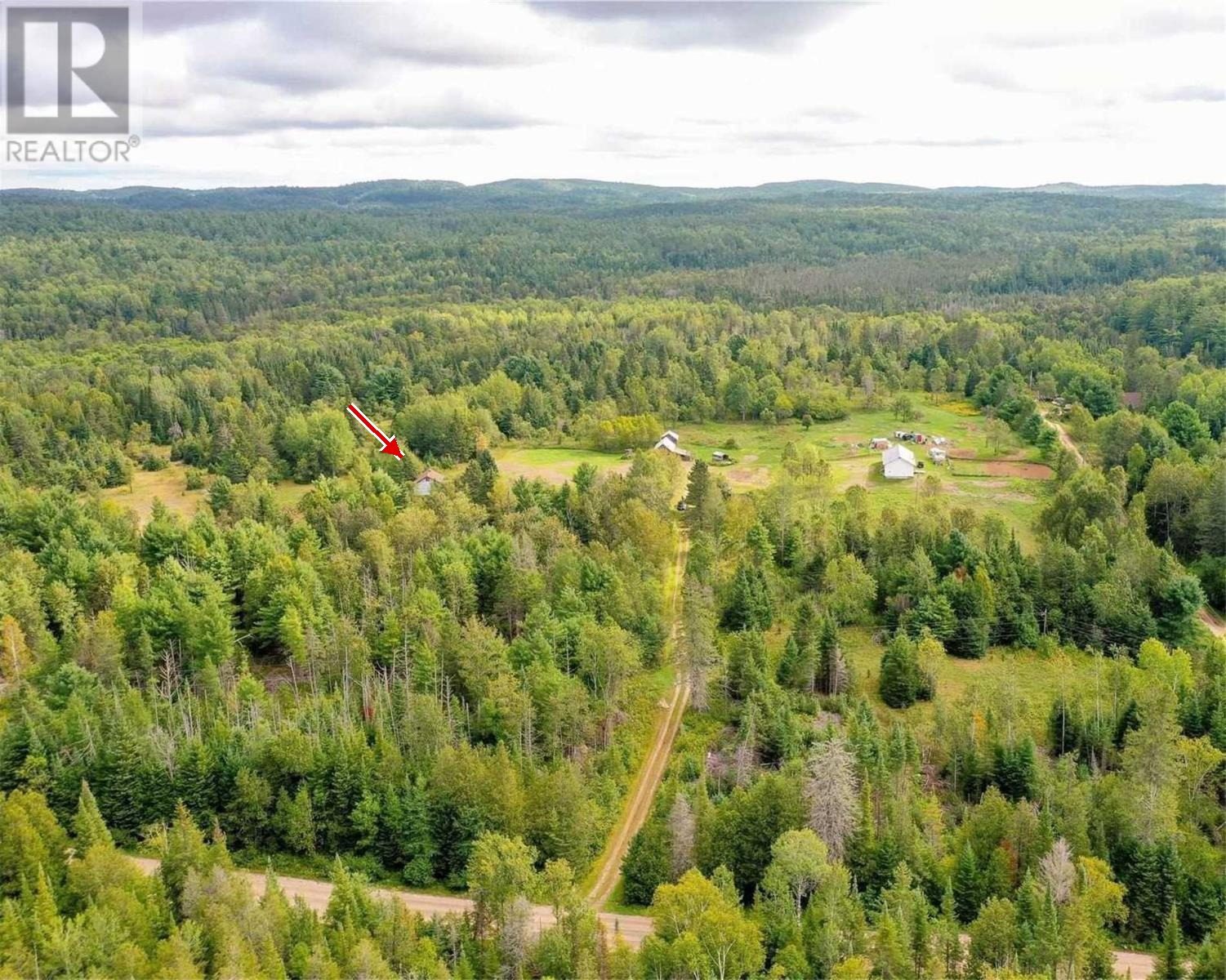 Aerial view of the property with an arrow marking the bunkie's location